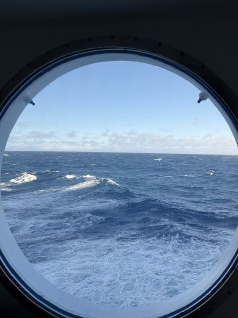 View of open sea through a cruise ship porthole on a lower deck